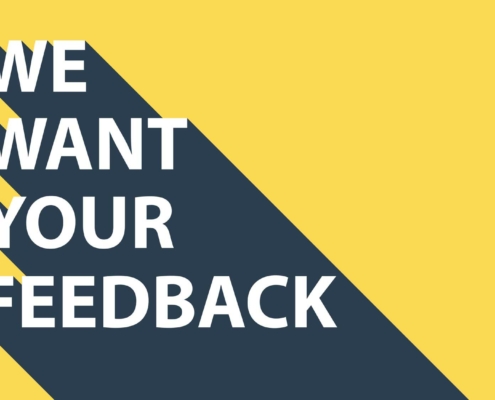 Yellow background with a diagonal dark gray shadow. Large white text in bold reads: "WE WANT YOUR FEEDBACK."