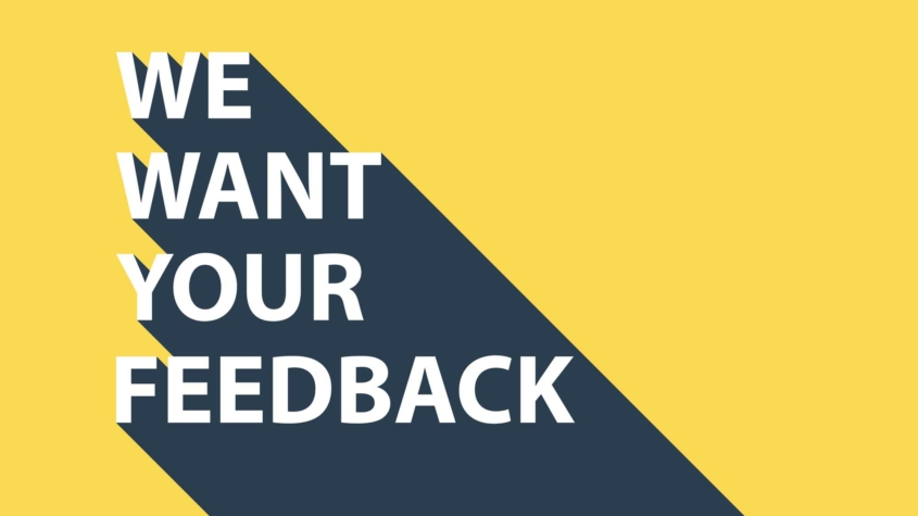 Yellow background with a diagonal dark gray shadow. Large white text in bold reads: "WE WANT YOUR FEEDBACK."